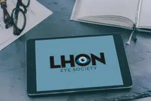 Logga för LHON Eye Society i svart text på blå bakgrund visas på en ipad